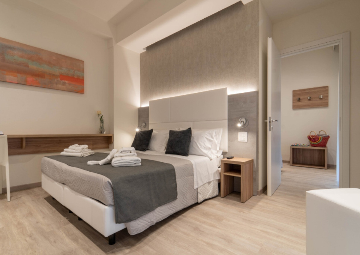 Camera moderna con letto matrimoniale, decorazioni eleganti e luce soffusa.