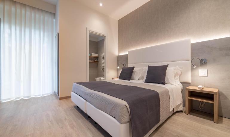 Camera moderna con letto matrimoniale e bagno privato.