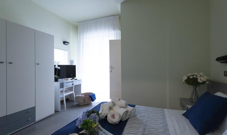 Camera luminosa, accogliente, con fiori freschi e asciugamani eleganti.