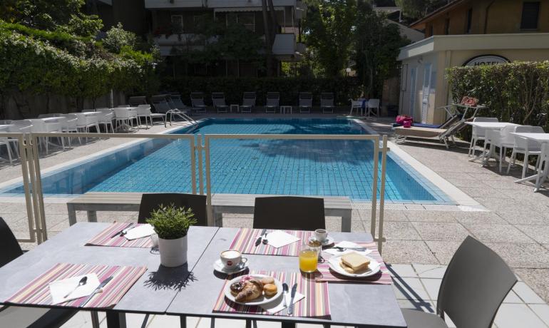 Colazione rilassante a bordo piscina in una giornata soleggiata.